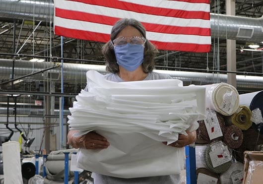 woman holding a stack of fabric